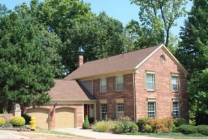 Picture of a brick house with a new asphalt shingle roof.
