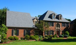 Picture of a large brick house with shingle roofing.