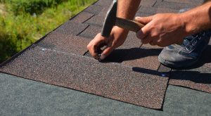 Contractor installing asphalt shingle roof