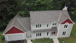 Aerial view of a two-story home with a light gray asphalt shingle roof